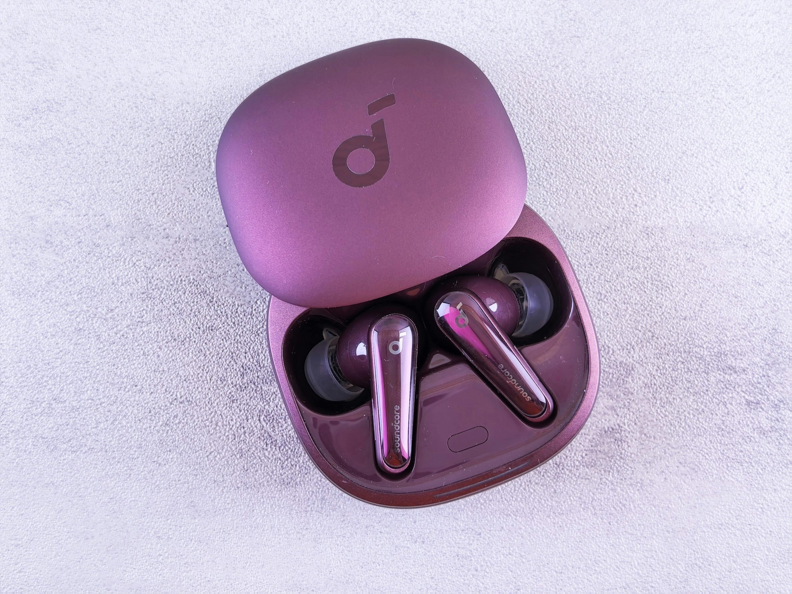 Modern purple earbuds resting in an open case, featuring glossy finish and sleek design.
